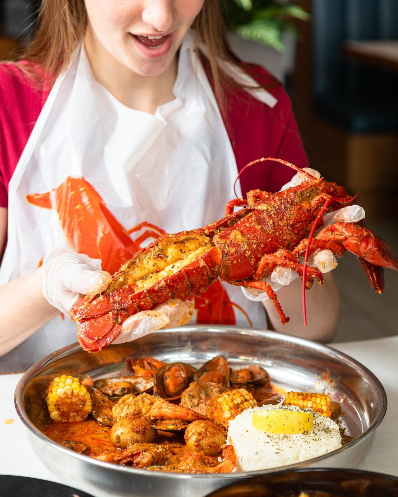 Guest holding whole lobster over boil tray