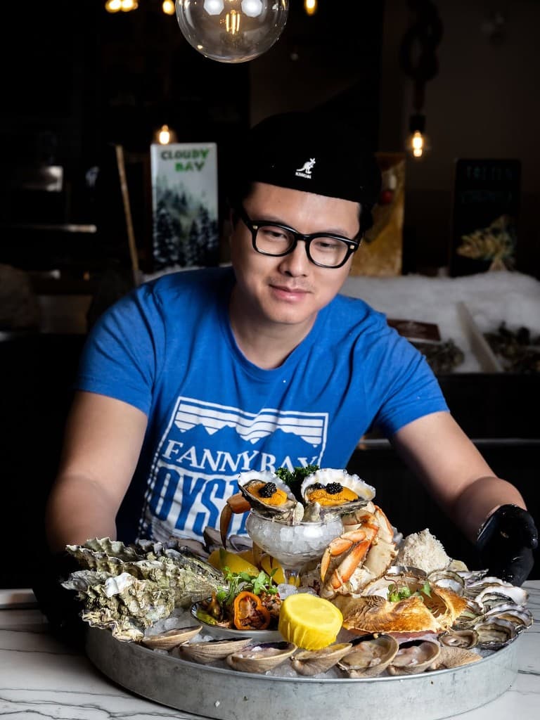 A Fanny Bay shucker with a shellfish tower at the Cambie Street bar
