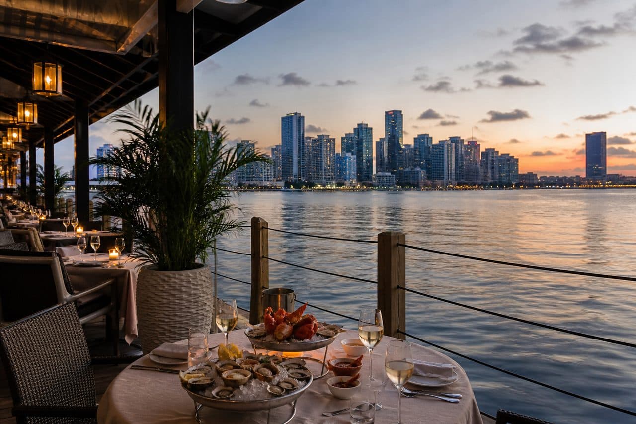 Miami Biscayne Bay waterfront dining patio with soft skyline at dusk